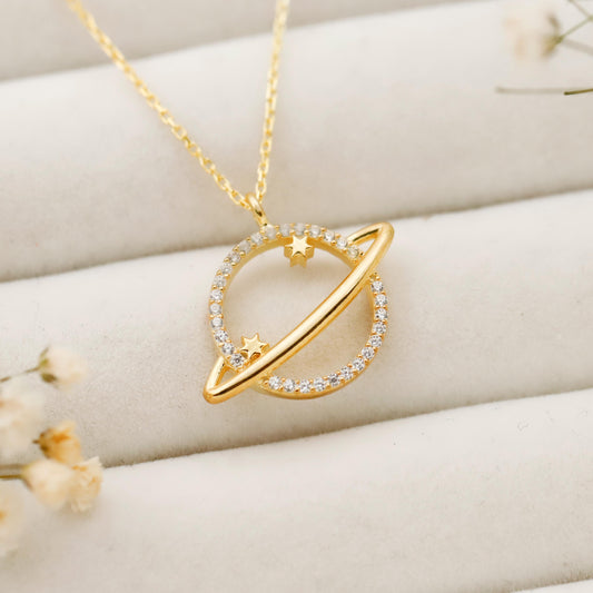 Gold necklace with a heart-shaped pendant on a soft beige background