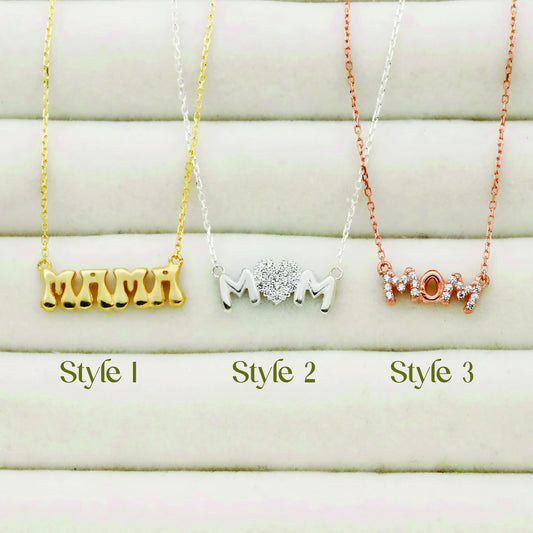 Three 'MOM' necklaces in different styles and colors on a white background