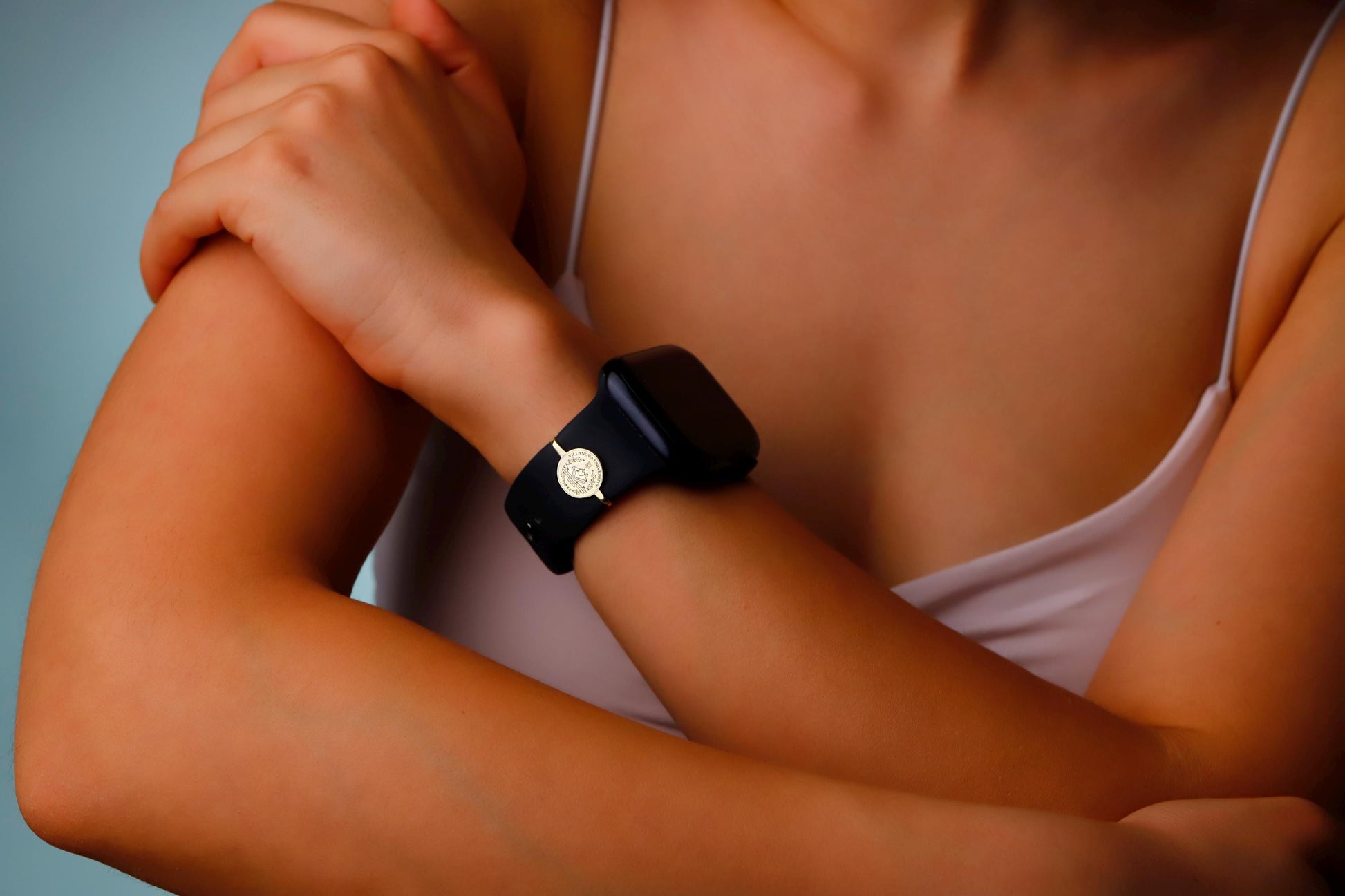 Person wearing a black smartwatch with a blurred background