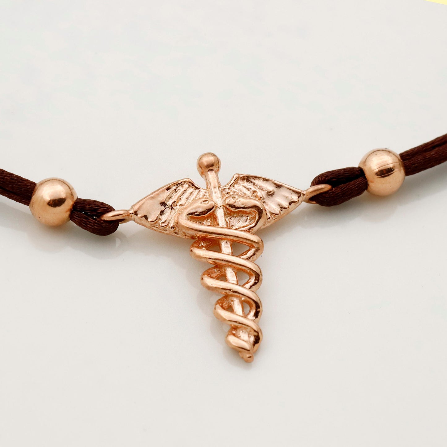 Rose gold medical symbol bracelet on a white background