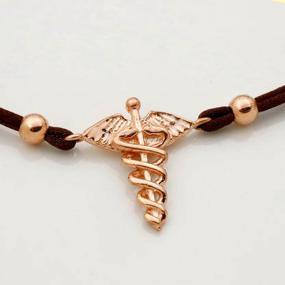 Rose gold medical symbol bracelet on a white background