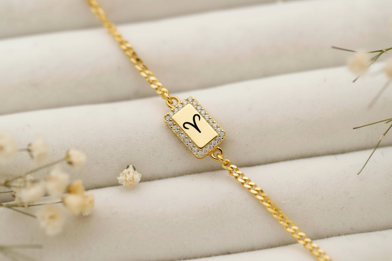 Gold bracelet with a decorative clasp on a soft surface with flowers.