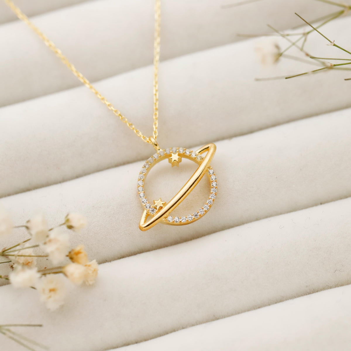 Gold necklace with a unique pendant on a soft beige background