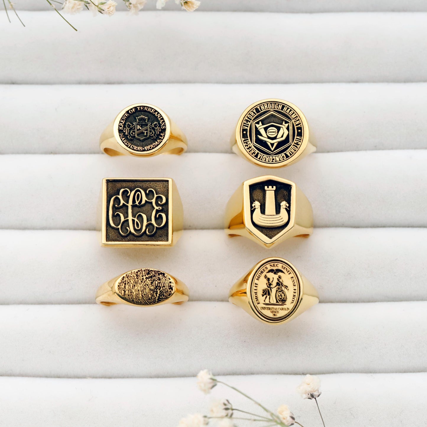 Collection of gold rings with various designs on a white surface.