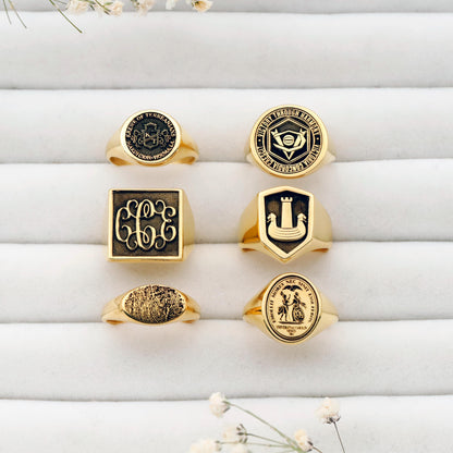 Collection of gold rings with various designs on a white surface.