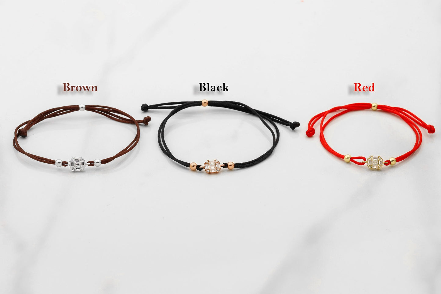 Three bracelets in brown, black, and red on a white background