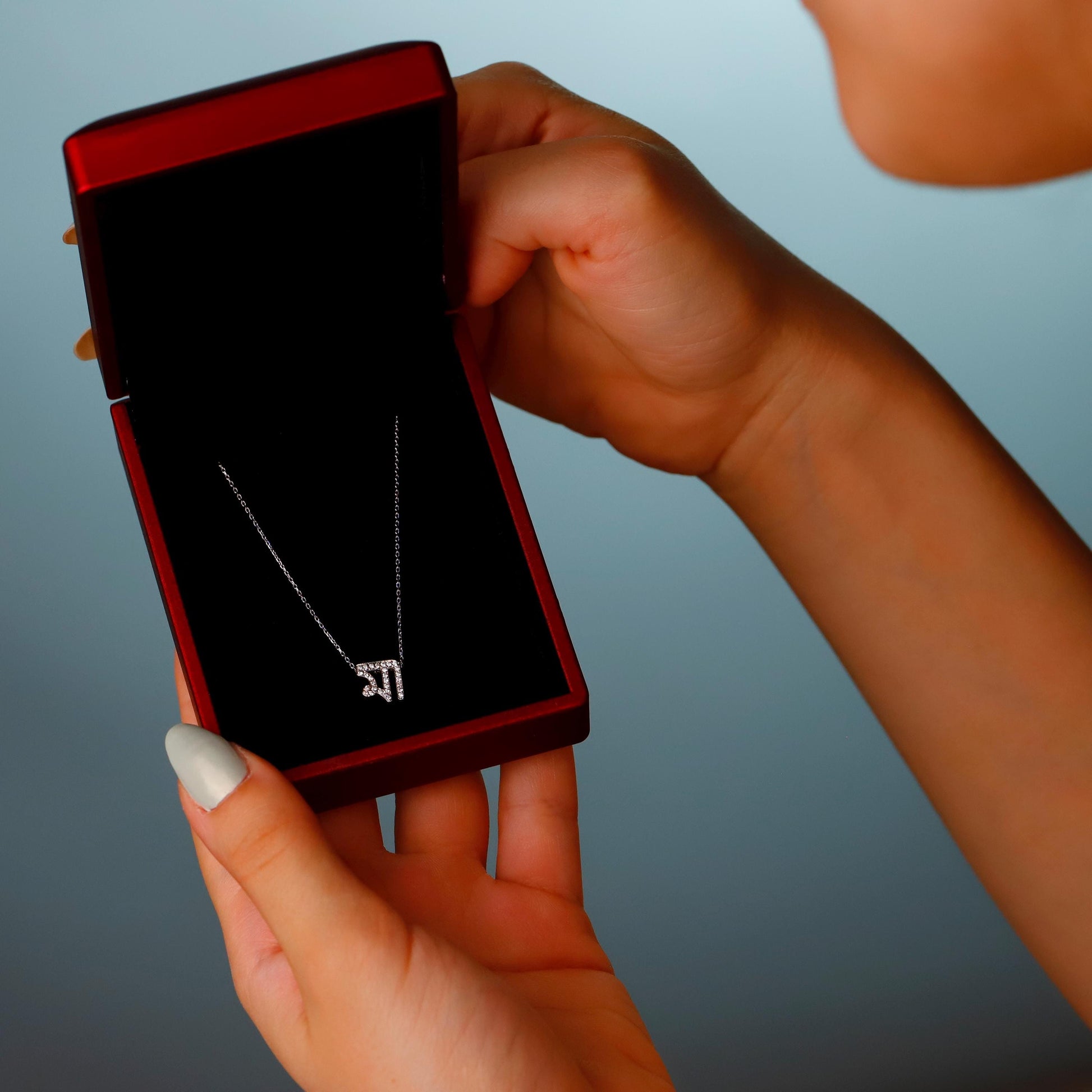 Person holding a red phone with a black screen against a gradient background