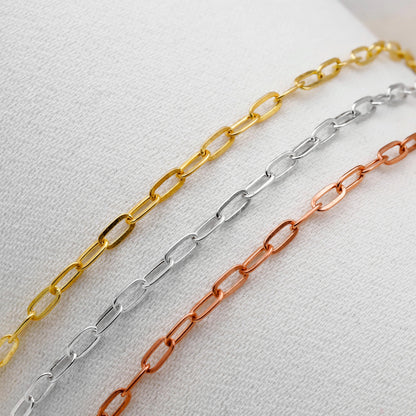 Three chain necklaces in gold, silver, and rose gold on a light gray background