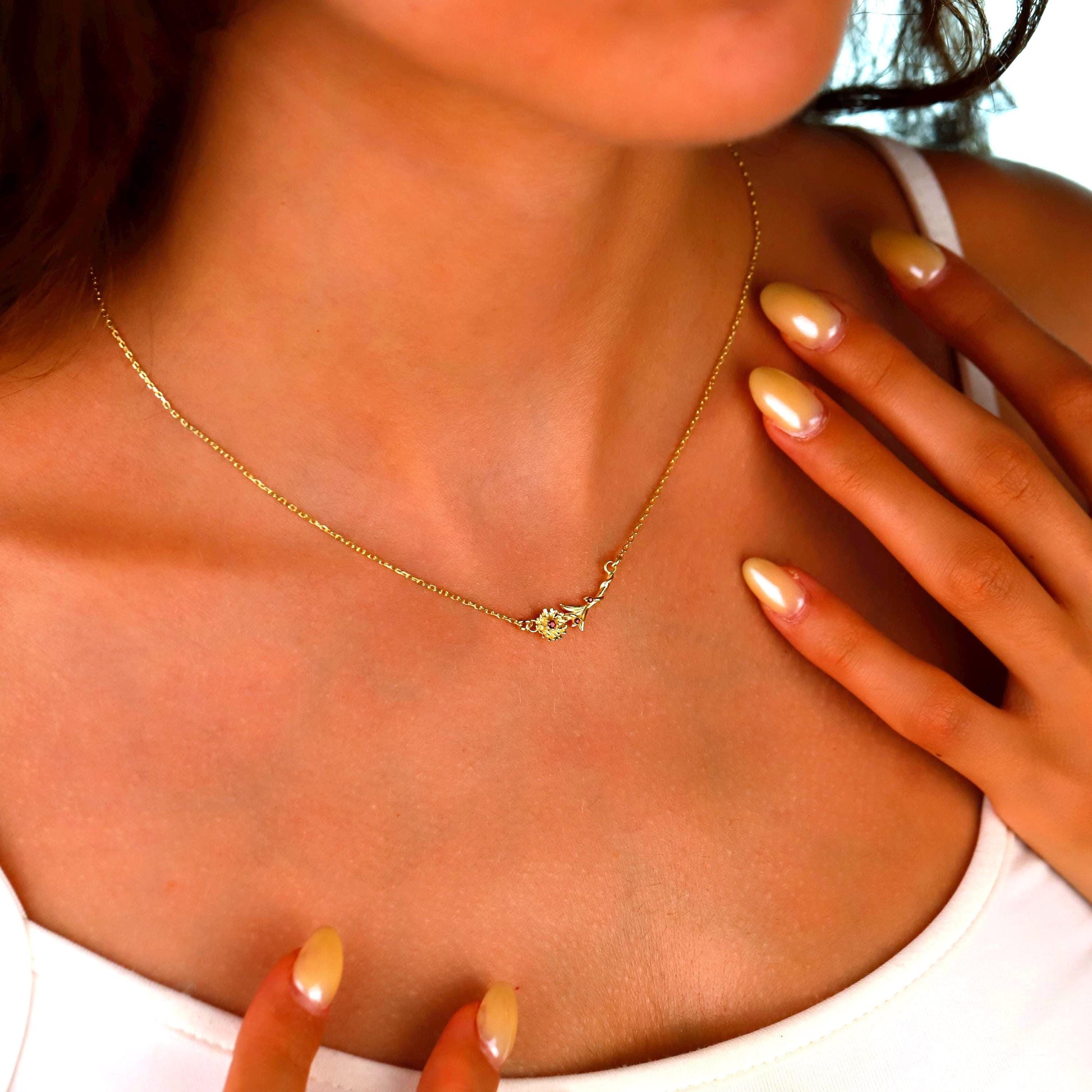 Close-up of a person wearing a gold necklace with a small pendant.