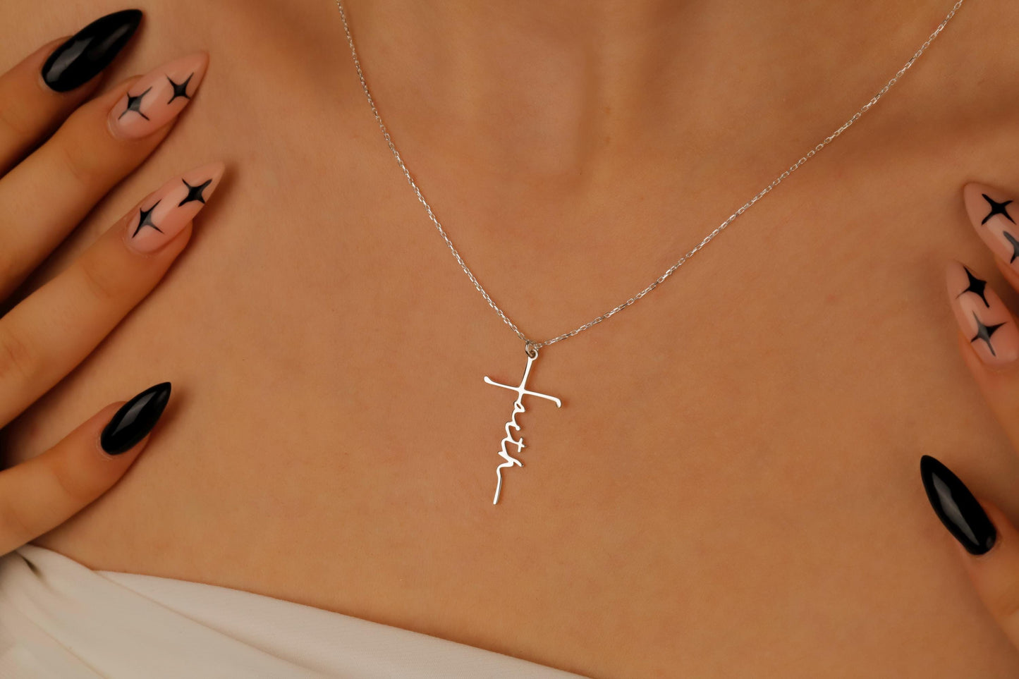 Silver necklace with a cross pendant on a person's neck