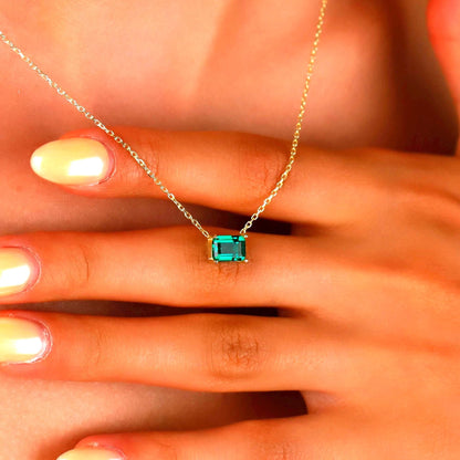 Green emerald necklace on a hand with a blurred background