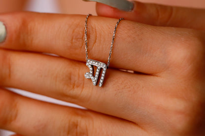 Silver necklace with a diamond pendant on a hand
