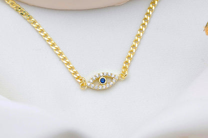 Gold chain necklace with an eye-shaped pendant featuring a blue gemstone on a white background