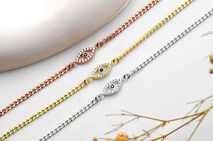 Three gold, rose gold, and silver bracelets with eye designs on a light background.