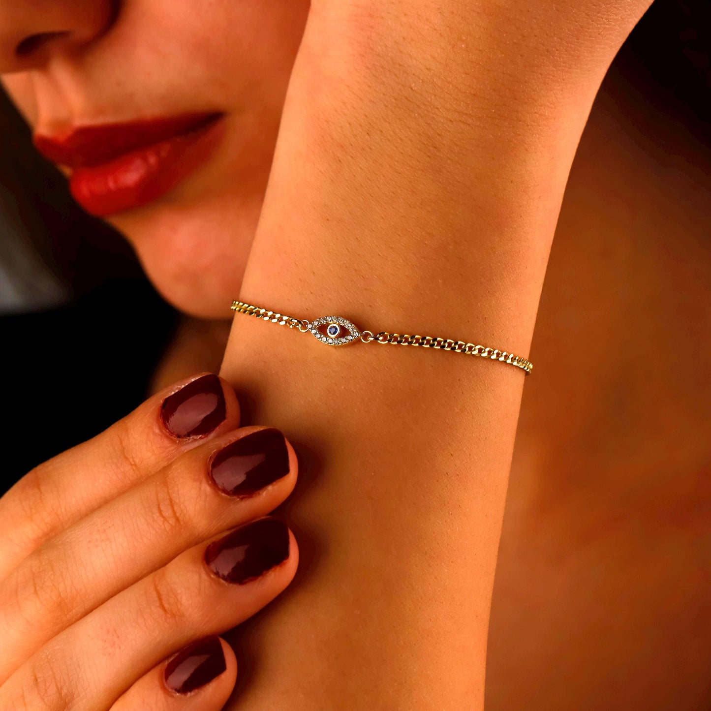 Close-up of a woman's arm wearing a silver bracelet with a dark background