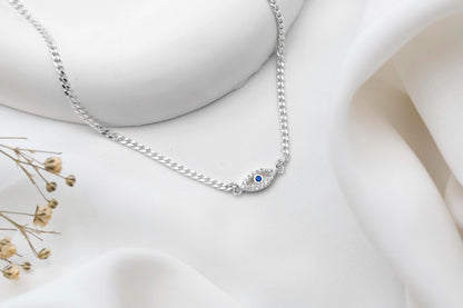 Silver bracelet with a blue gemstone on a white fabric background