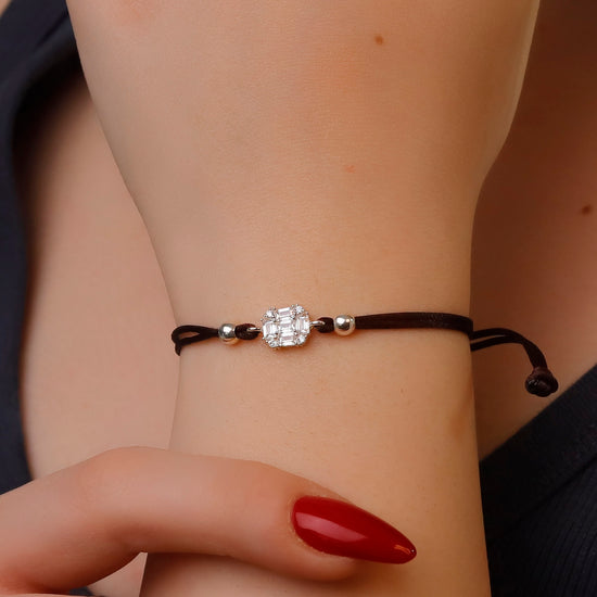 Bracelet with a decorative clasp on a wrist with red nail polish.
