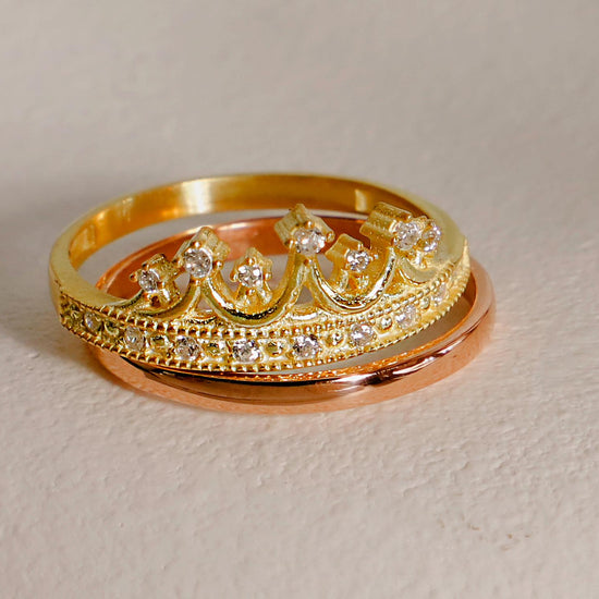 Two gold rings with diamond accents on a white background