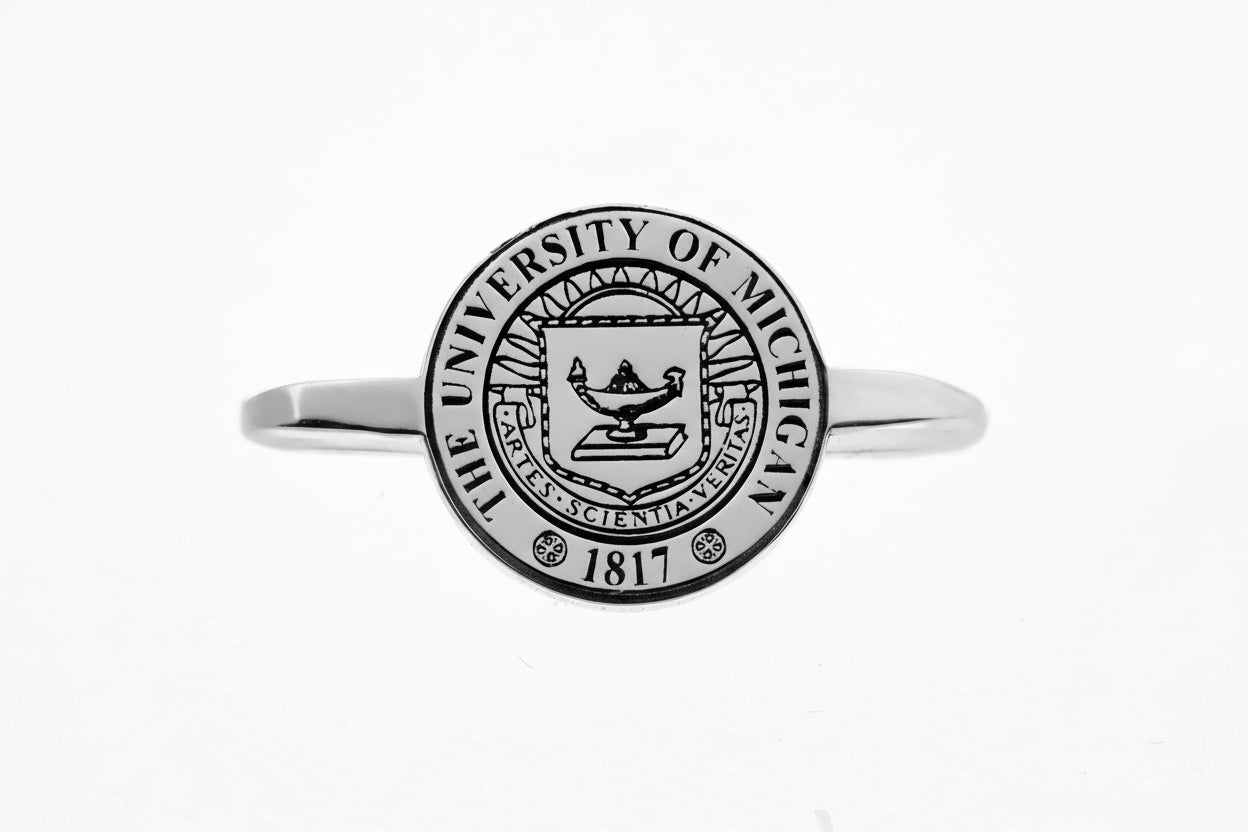 Silver rings with The University of Michigan crest on a white background