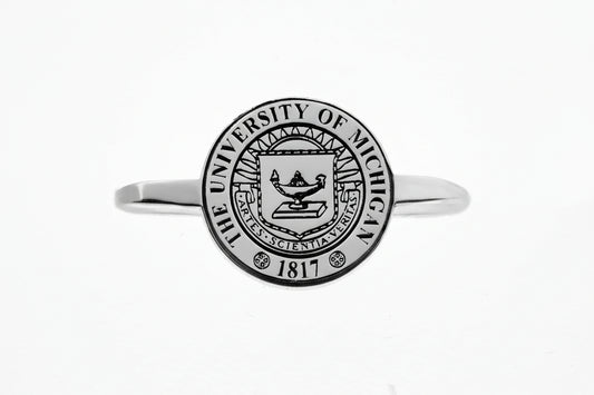 Silver rings with The University of Michigan crest on a white background